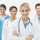 Young doctor standing in front with 3 doctors behind her