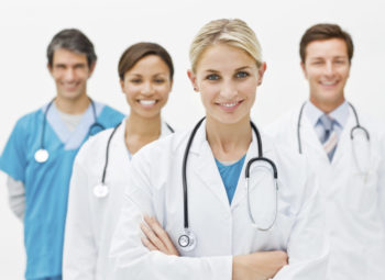 Young doctor standing in front with 3 doctors behind her