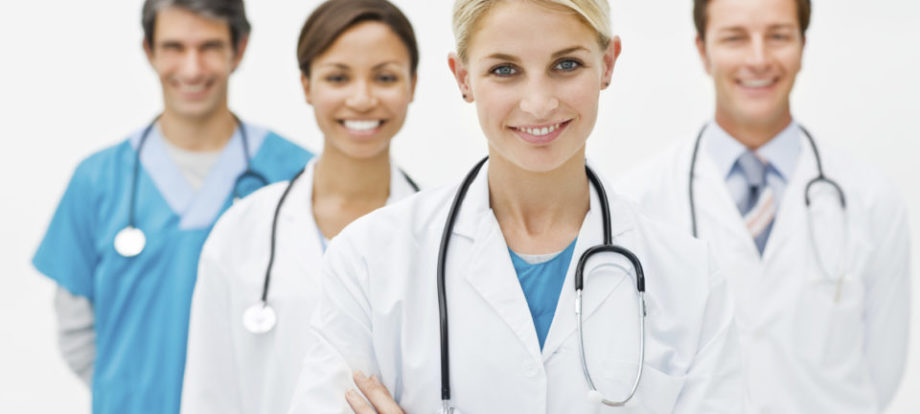 Young doctor standing in front with 3 doctors behind her